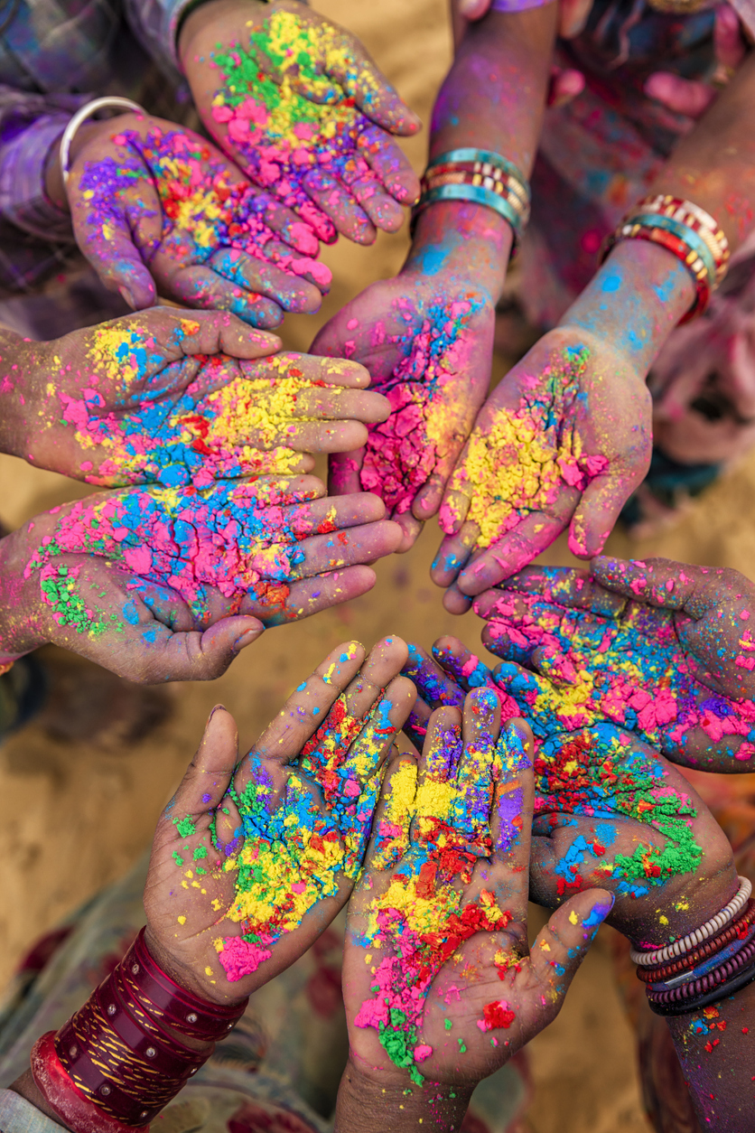 Indian children keeping their hands up and showing colorful powders (Photo: iStockphoto)
