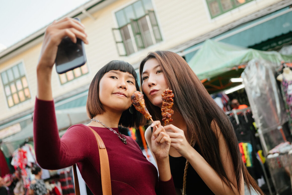 นักท่องเที่ยวถ่ายภาพเซลฟี่กับหมูปิ้ง สตรีตฟูดของไทย (เครดิตรูปภาพ: iStockphoto)