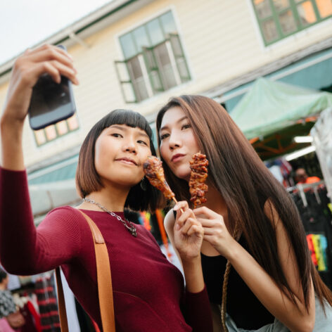 นักท่องเที่ยวถ่ายภาพเซลฟี่กับหมูปิ้ง สตรีตฟูดของไทย (เครดิตรูปภาพ: iStockphoto)