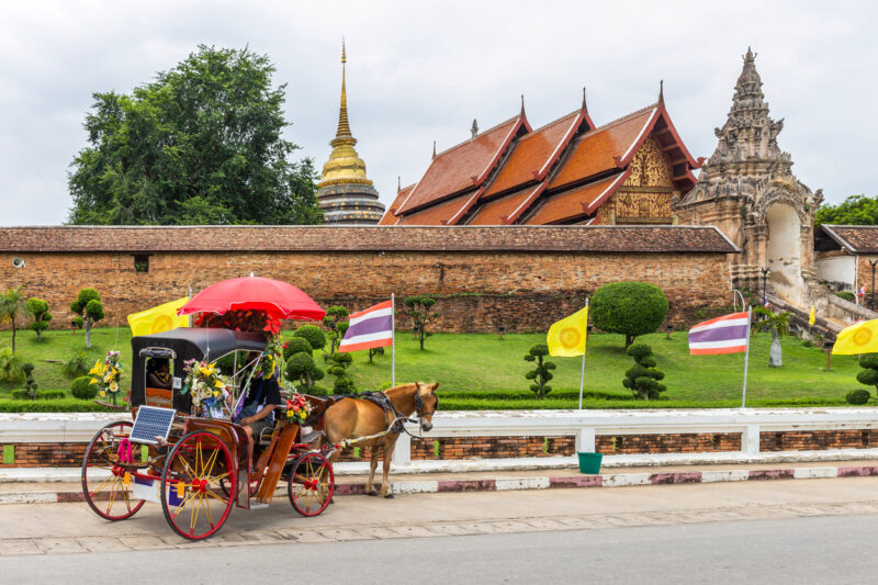 Horse carriage waiting to service tourists in front of Wat Phra That Lampang Luang (Photo Credit: iStockphoto)