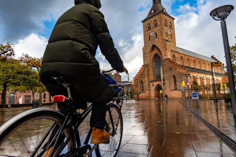 Odense residents cycle past St. Canute's Cathedral, a church in the old town. (Photo Credit: iStockphoto)