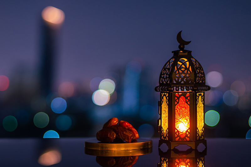 City lights behind the lantern during the month of Ramadan.