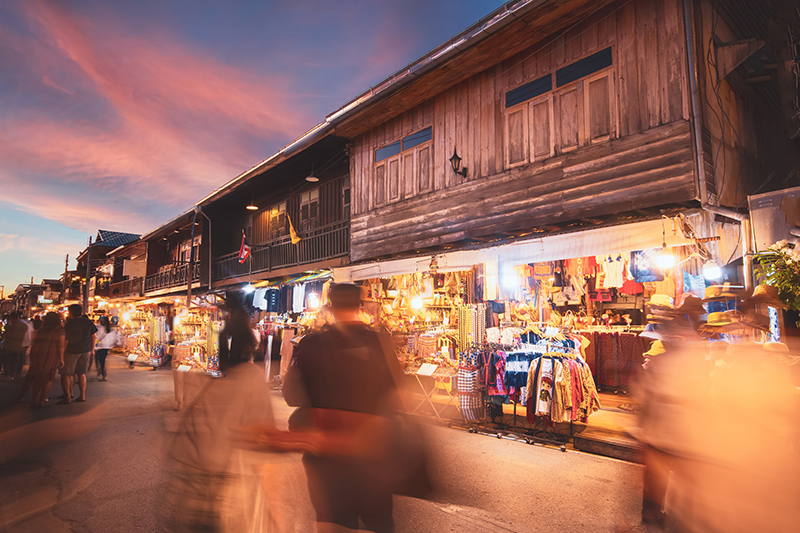 The bustling walking street and night market in Chiang Khan during twilight.
