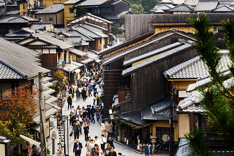 A street lined with traditional Japanese wooden buildings featuring tiled roofs.