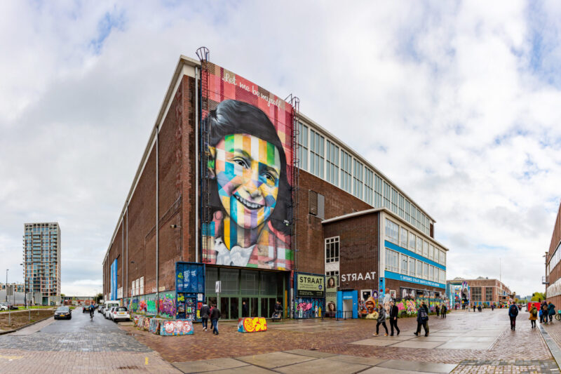 A famous picture of the Let Me Be Myself colorful mural, depicting Anne Frank, created by Eduardo Kobra in 2016, on the wall of the STRAAT Museum.