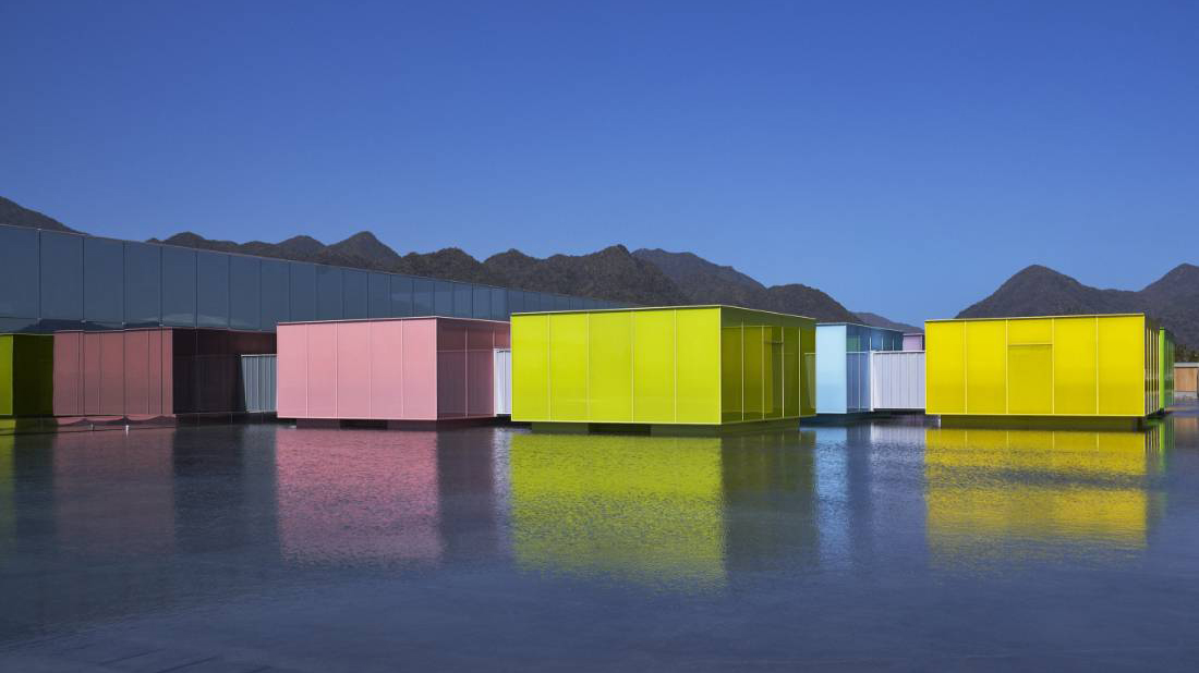 Eight movable 10-meter galleries float across the basin, each wrapped in a distinct shade of luminous colored glass.